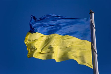Foto de Flag of Ukraine against the blue sky close-up. National pride and symbol of the country Ukraine. War in Ukraine. Yellow-blue flag. - Imagen libre de derechos