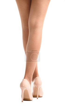 Photo for Slender female legs in transparent beige tights and elegant beige high-heeled shoes on a white background, isolated. Close-up of the beautiful legs of a girl posing in high heeled shoes - Royalty Free Image