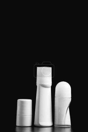Téléchargez les photos : Ensemble de roll-on déodorant blanc antisudorifique, isolé sur fond noir, maquettes d'emballages en plastique blanc pour l'hygiène personnelle, récipients avec couvercle pour protéger la peau de la sueur et des odeurs. - en image libre de droit