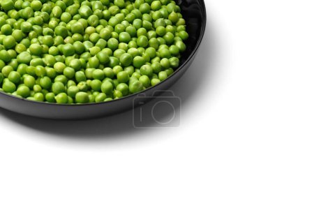 Photo for Peeled grains of fresh green peas in a round black plate on a white background, copy space. Vegetable protein, healthy products. - Royalty Free Image