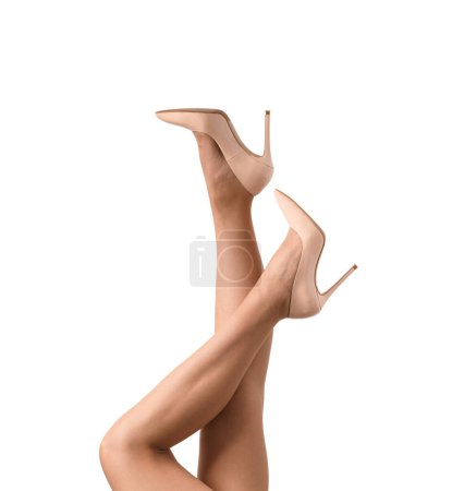 Photo for Slender female legs in transparent beige tights and elegant beige high-heeled shoes on a white background, isolated. Close-up of the beautiful legs of a girl posing in high heeled shoes - Royalty Free Image