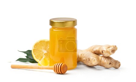 Photo for Organic honey in a closed glass transparent jar, a wooden dipper, ginger and a cut lemon with green leaves isolated on a white background. Honey, honey stick and citrus fruits close-up. - Royalty Free Image