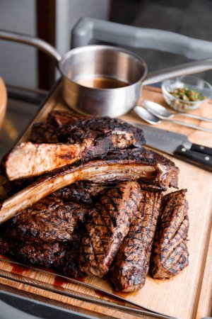 Téléchargez les photos : Différents types de délicieux steaks grillés juteux sur une planche de bois dans un restaurant. Ribeye steak, filet cuit au feu. B-B-Q. - en image libre de droit