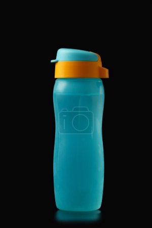Foto de Botella eco-plástica colorida reutilizable para agua y otras bebidas frías y calientes sobre un fondo negro. Protección medioambiental. - Imagen libre de derechos