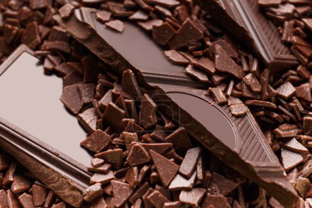 Foto de Trozos de chocolate negro roto en chispas de chocolate de cerca. Fondo de chocolate. - Imagen libre de derechos