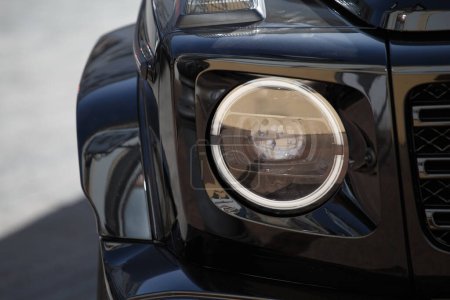 Téléchargez les photos : Partie avant d'une voiture moderne SUV noir avec phare et roue. Conception de voiture. - en image libre de droit