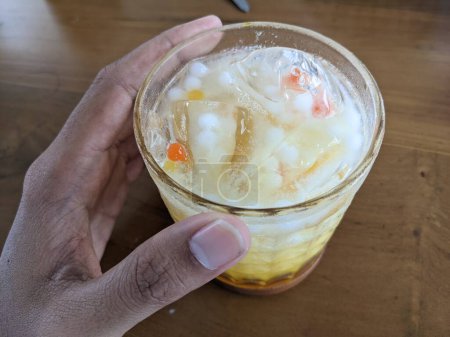 Téléchargez les photos : Glace à la mangue Yakult avec du lait frais et un peu de pulpe. La photo est adaptée à l'utilisation pour fond de café, affiche de menu et médias de contenu de café. - en image libre de droit