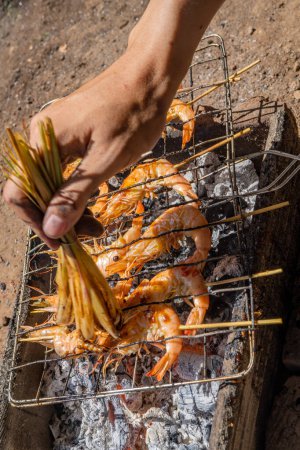 Photo for Shrimp grilled over the charcoal fire when summer party. the photo is suitable to use for grilled content media and party poster. - Royalty Free Image