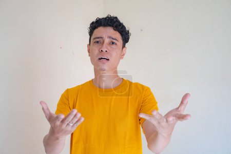 Young man with why pose, asking gesture. The photo is suitable to use for man expression advertising and fashion life style.