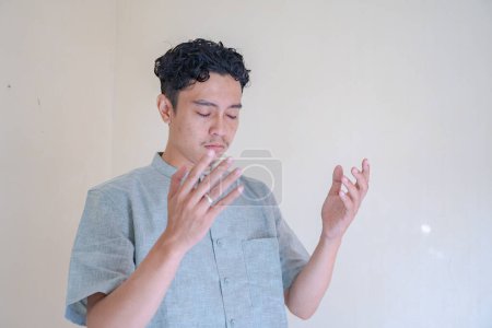Hombre musulmán asiático gesto de oración cuando la celebración del Ramadán. La foto es adecuada para usar para póster de Ramadán y medios de contenido musulmán.