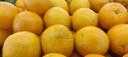 Téléchargez les photos : View of pile of oranges being sold in market place, top view of sunkist oranges, yellow round fruits, fresh fruit background - en image libre de droit