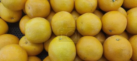 Photo for View of pile of oranges being sold in market place, top view of sunkist oranges, yellow round fruits, fresh fruit background - Royalty Free Image