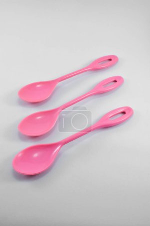 Foto de Small pink plastic spoon isolated on white background. - Imagen libre de derechos