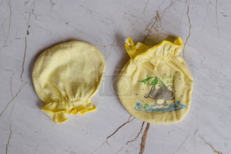 Foto de Yellow baby gloves, Baby gloves look small and funny. - Imagen libre de derechos