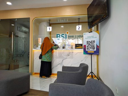 Foto de Pandaan, 13 January 2023 - Teller counter at Bank Syariah Indonesia (BSI). Bank BSI employees are serving visitors - Imagen libre de derechos