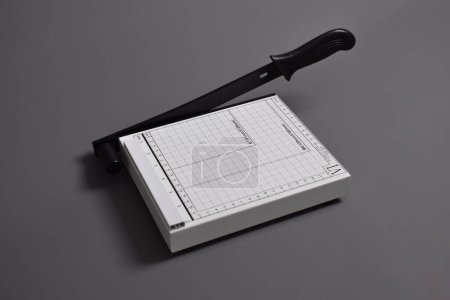 Foto de Cortador de papel blanco aislado sobre fondo gris - Imagen libre de derechos