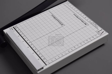 Foto de Cortador de papel blanco aislado sobre fondo gris - Imagen libre de derechos