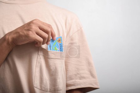  Una persona muestra y sostiene tarjetas de identidad indonesias (KTP) sobre fondo blanco.