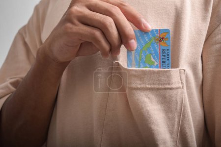  A person shows and holds Indonesian identity cards (KTP) on white background.