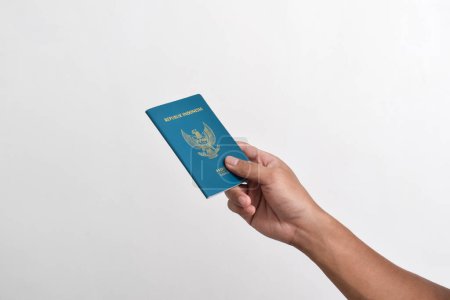 Foto de Hombre sosteniendo pasaporte indonesio aislado sobre fondo blanco - Imagen libre de derechos