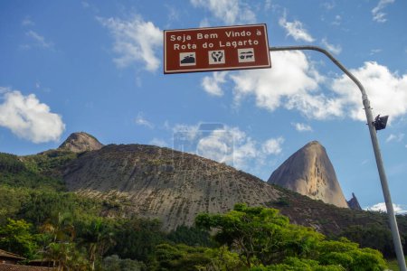 Foto de Bienvenido a la placa de Rota do Lagarto, con formación de roca Pedra Azul en la espalda. Domingos Martins, ES, Brasil. - Imagen libre de derechos