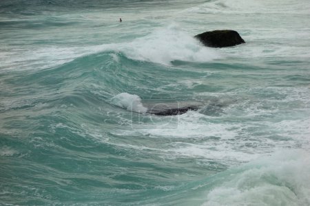 ocean waves crash against rocks on the coast during storm.