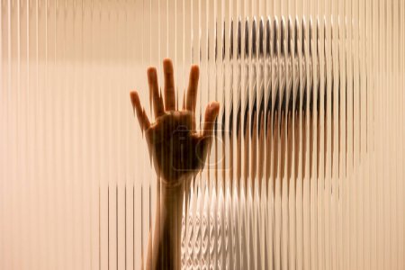 Téléchargez les photos : One hand on the textured glass - en image libre de droit