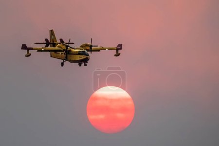 Téléchargez les photos : Incendie dévastateur à Alexandroupolis Evros Grèce, Avions de bombardement aérien silhouette, fumée a couvert le ciel, couleurs du coucher du soleil. - en image libre de droit