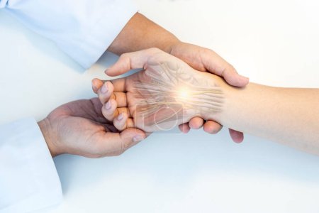Photo for The orthopedic doctor or surgeon in uniform examined the patient with numbness of hand.Wrist pain in carpal tunnel syndrome with transparent anatomy of median nerve.Light effect on white background. - Royalty Free Image