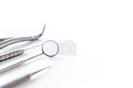 Zbliżenie przyrządu stomatologicznego lub sprzętu wyizolowanego na białym czystym tle rozmycia wewnątrz kliniki stomatologicznej w szpitalu.Stomatologiczne lusterko, separator Gigiwarowy i sonda na ból zęba lub ortodontyczne.