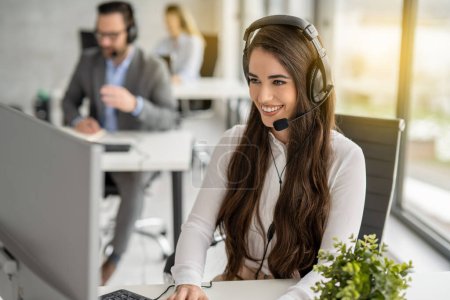 Foto de Customer service representative woman in headphones working at modern office. - Imagen libre de derechos