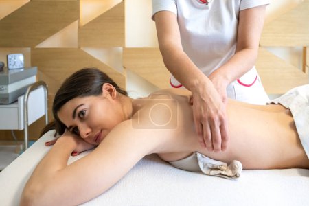 Foto de Mujer joven teniendo masaje corporal en el salón de spa. - Imagen libre de derechos