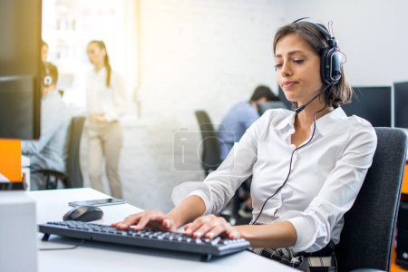 Customer support woman operator being tired after working on computer at her second shift in the office. Overwork and underpaid concept.