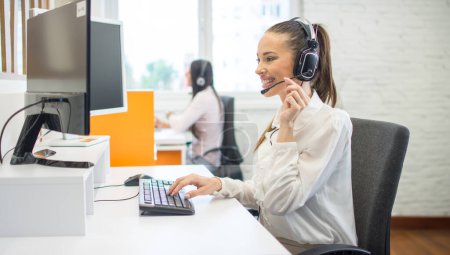 Foto de Sonriente de atención al cliente mujer trabajadora telefónica de consultoría y asistencia al cliente a través de llamada telefónica. - Imagen libre de derechos