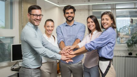Téléchargez les photos : Groupe de collègues d'affaires empilant les mains ensemble montrant l'unité de leur équipe au bureau. - en image libre de droit