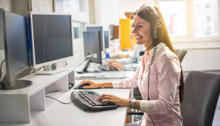 Photo for Call center agent with headset working on support hotline in call center office. - Royalty Free Image