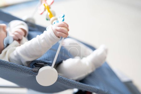 Téléchargez les photos : Vue grand angle de bébé méconnaissable jouant dans son fauteuil oscillant à bascule à la maison. - en image libre de droit