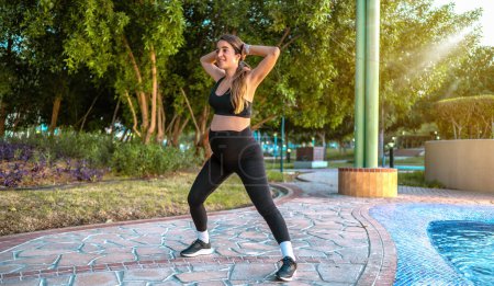 Téléchargez les photos : Pleine longueur de femme enceinte en vêtements de sport faisant de l'exercice dans le parc - en image libre de droit
