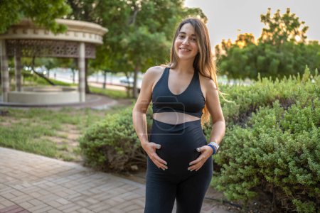 Téléchargez les photos : Belle jeune femme enceinte debout dans le parc le jour de l'été - en image libre de droit