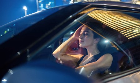 Téléchargez les photos : Belle jeune femme au volant de voiture la nuit - en image libre de droit