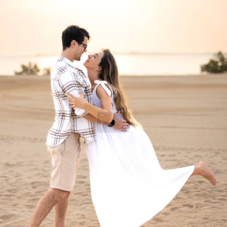 Photo for Beautiful young couple in love having fun together on the beach, looking to each other. Happy couple expecting baby - Royalty Free Image