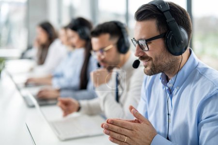 Photo for Close up portrait of handsome man with headset successfully solving task to his client during online chat in call center. - Royalty Free Image