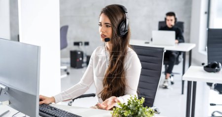 Photo for Young operator woman having online voice chat in call center office - Royalty Free Image