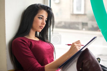 Photo for Young women and education, female student studying for college exam near the window. - Royalty Free Image