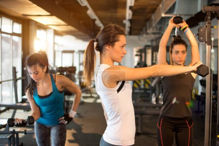 Photo for Three pretty girls workout in the gym. - Royalty Free Image