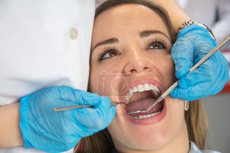 Photo for Dentist examining a patients teeth in the dental office. - Royalty Free Image