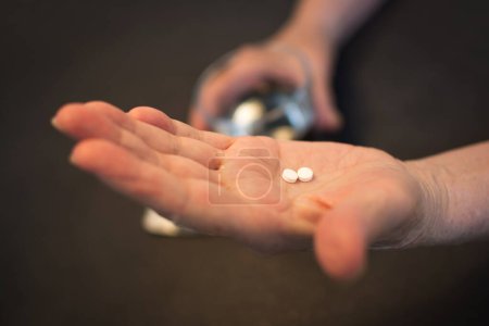 Photo for Senior woman taking pills with a glass of water. - Royalty Free Image