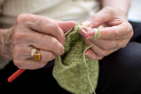Téléchargez les photos : Gros plan des mains d'une femme âgée à tricoter. - en image libre de droit