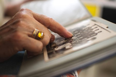 Téléchargez les photos : Femme âgée main touchant une vieille photo. Gros plan. - en image libre de droit