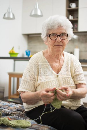 Photo for Elderly woman knitting at home. - Royalty Free Image